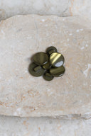 Boutons ronds bombés à queue, sans trous apparents, finition nacrée vert olive kaki, présentés en tas de tailles variées sur une dalle de pierre beige marbrée.