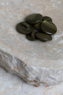 Top-down view of the buttons, stacked at the centre of a marbled beige stone.