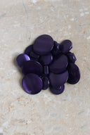 The buttons viewed from above, stacked at the center of a marbled beige stone.