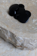 The buttons viewed from above, stacked at the center of a marbled beige stone.