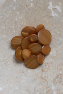 Autre vue rapprochée des boutons sur la pierre beige marbrée, sous un angle différent.