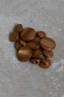 Top-down view of the buttons, stacked at the centre of a marbled beige stone.