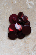 Top-down view of the buttons, stacked at the centre of a marbled beige stone.