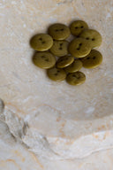 The buttons viewed from above, stacked at the center of a marbled beige stone.