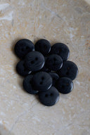 The buttons viewed from above, stacked at the center of a marbled beige stone.