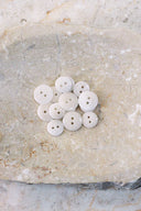 Close-up of the same buttons on the edge of a marbled beige stone.