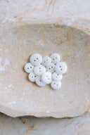 Close-up of the same buttons on the edge of a marbled beige stone.