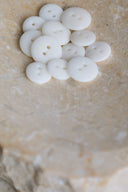 The buttons viewed from above, stacked at the center of a marbled beige stone.