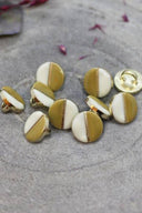 Close-up of the same two-tone buttons, highlighting the gold edge separating the two shades.