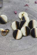 Close-up of the same two-tone buttons, highlighting the gold edge separating the two shades.