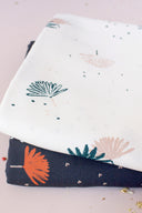 Tissus Palmetto ivoire et marine pliés ensemble, montrant le même motif de feuilles de palmier dans les deux coloris de la collection.