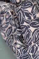 Petal fabrics folded side by side, interlocking-circles pattern in two colorways: navy and off-white on a taupe background, and navy on an off-white background.