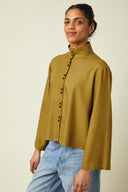 Patron Chemise Amirale – Femme de face, chemise kaki ample, col officier, boutonnage double, fond beige – Atelier Brunette