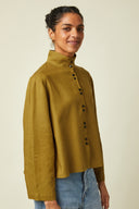 Patron Chemise Amirale – Femme de 3/4, chemise amirale kaki ample portée avec jean, fond beige – Atelier Brunette