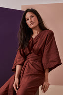 Combi Addie pattern – bust shot, burgundy jumpsuit with crossed V neckline, tied belt – Atelier Brunette