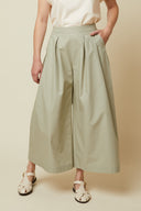 Culotte Skirt pattern – front view, culotte skirt sage green, white t-shirt, hand in pocket, front pleats – Atelier Brunette