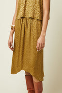 Déroutante Skirt pattern – Woman, 3/4 view, skirt flared gold leopard print asymmetric, tall caramel boots – Atelier Brunette