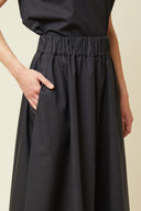 Vertigo Skirt pattern – half-body front view, colourway black, hands in pockets – Atelier Brunette