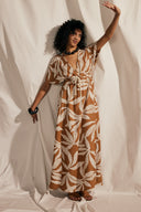 Butterfly Dress pattern – Woman with raised arm, dress caramel foliage motif, kimono sleeves, curtain background – Atelier Brunette
