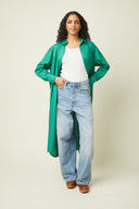Patron Robe Chemise – Robe chemise verte portée ouverte sur jean large et t-shirt blanc, fond beige – Atelier Brunette
