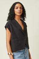 Spencer Jacket pattern – front view, jacket spencer black, crossed tailored collar, cap sleeve, beige background – Atelier Brunette