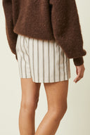 Boxer shorts pattern – half-body front view, boxer shorts striped beige, brown cardigan, hand in pocket – Atelier Brunette