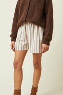 Boxer shorts pattern – model, full length, boxer striped beige white, dark brown cardigan, beige background – Atelier Brunette