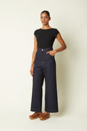 Patron Jean Wide Leg – vue de face, jean wide leg denim brut, taille haute, top noir, clogs camel – Atelier Brunette
