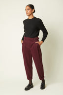 Belted Trousers pattern – Front view, trousers burgundy high waist, gold buckle belt, black jumper – Atelier Brunette