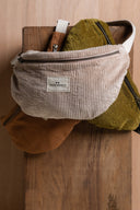 Patron Sac Banane – Sac banane velours côtelé écru, fermeture éclair dorée, vue de face fond bois – Atelier Brunette