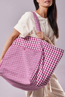Patron Sac de plage – Femme portant sac oversize vichy rose/blanc sur épaule, t-shirt blanc, fond lilas – Atelier Brunette