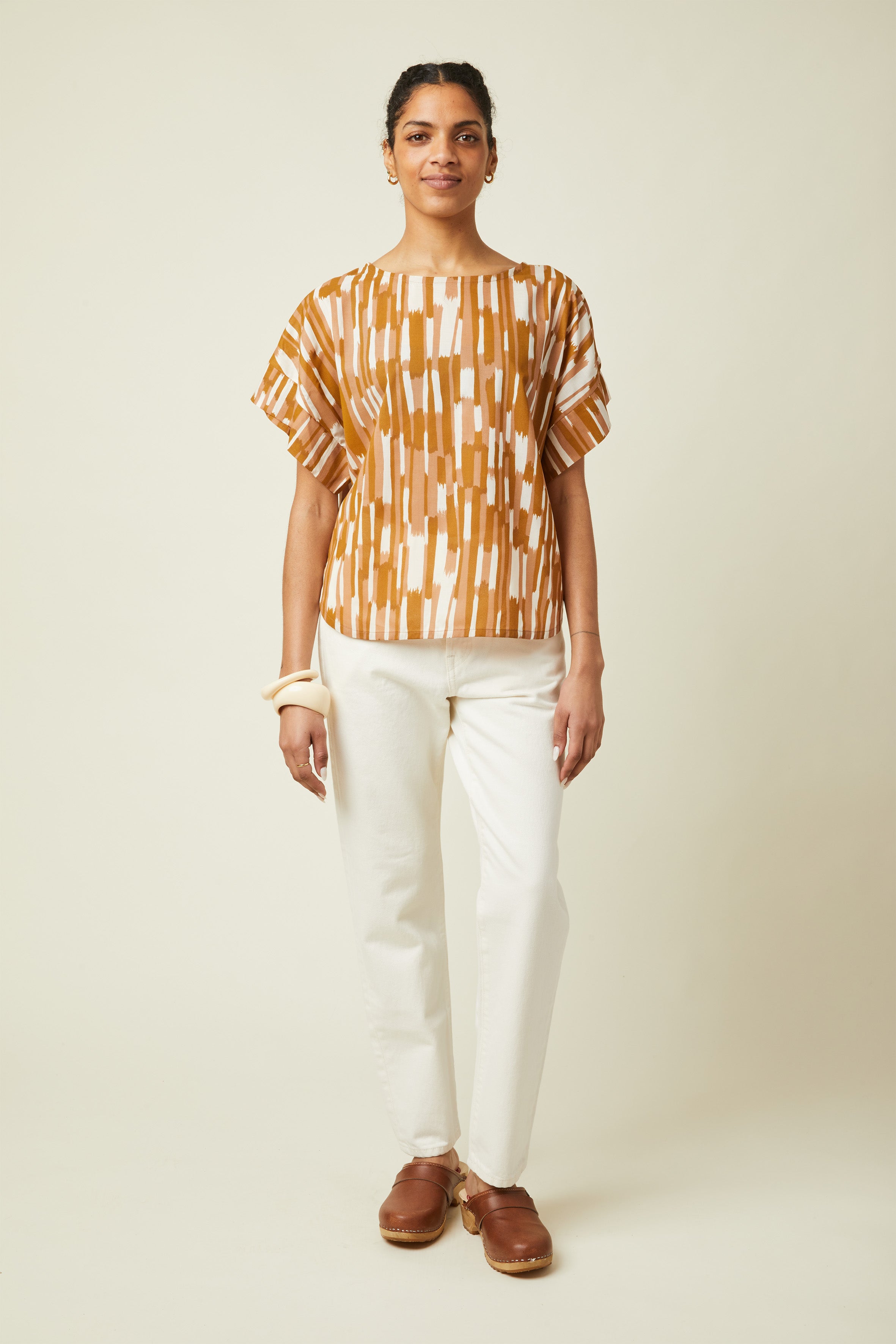 Patron Le Top Oversize – Femme de face, top imprimé ocre/terracotta, col bateau, pantalon blanc – Atelier Brunette