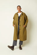 Patron Trench – vue de face, trench kaki long, col chemise, patte boutonnage, jean gris, derbies bordeaux – Atelier Brunette