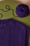 Jumper and Cardigan knitting pattern – knitted purple waistcoat flat-lay with ball of wool, background khaki – Atelier Brunette