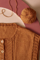 Jumper and Cardigan knitting pattern – knitted mustard waistcoat flat-lay with ball of wool, background pink – Atelier Brunette