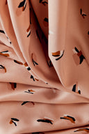Gros plan sur le tissu drapé, mettant en valeur la répartition des motifs confettis colorés.