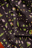 Tissu Candy Rock noir plié, montrant la répétition du motif confettis sur toute la surface.