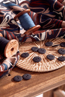 Close-up of the navy and terracotta floral pattern on the softly draped Hilma River fabric.