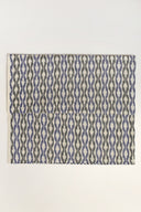 Tissu L'Ikat écru plié à plat, motif de rayures ondulées bleu et anthracite façon ikat visible sur l'ensemble de la pièce.
