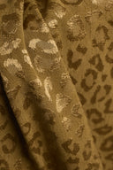 Leony viscose jacquard fabric with a camel and gold leopard print, draped in soft folds showing off its satiny finish.