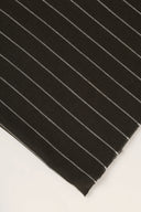 La Rayure 002 charcoal fabric with fine ecru stripes, rolled up showing the woven selvedge.