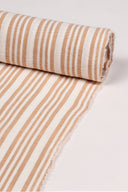 Close-up of the corner of the La Rayure 003 ecru fabric with caramel vertical stripes, highlighting the pattern and the frayed selvedge.