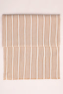 La Rayure 003 ecru fabric with caramel vertical stripes, folded in half and viewed from above.