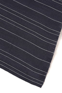 La Rayure 007 navy fabric with fine ecru horizontal stripes, rolled up showing the woven selvedge.
