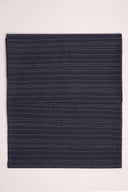 La Rayure 007 navy fabric with fine ecru horizontal stripes, folded in half and viewed from above.