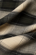 Le Carreau 005 ecru fabric with tartan-style charcoal checks, folded flat, with a frayed selvedge visible.