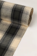 Close-up of the corner of the Le Carreau 005 ecru fabric with tartan-style charcoal checks, highlighting the pattern and the frayed selvedge.