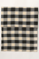 Le Carreau 005 ecru fabric with tartan-style charcoal checks, folded in half and viewed from above.
