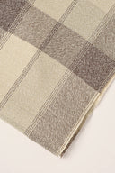 Tissu Le Carreau 006 écru à carreaux taupe chiné façon tartan, enroulé en rouleau laissant voir la lisière tissée.