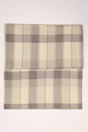 Tissu Le Carreau 006 écru à carreaux taupe chiné façon tartan, plié en deux et vu de dessus.